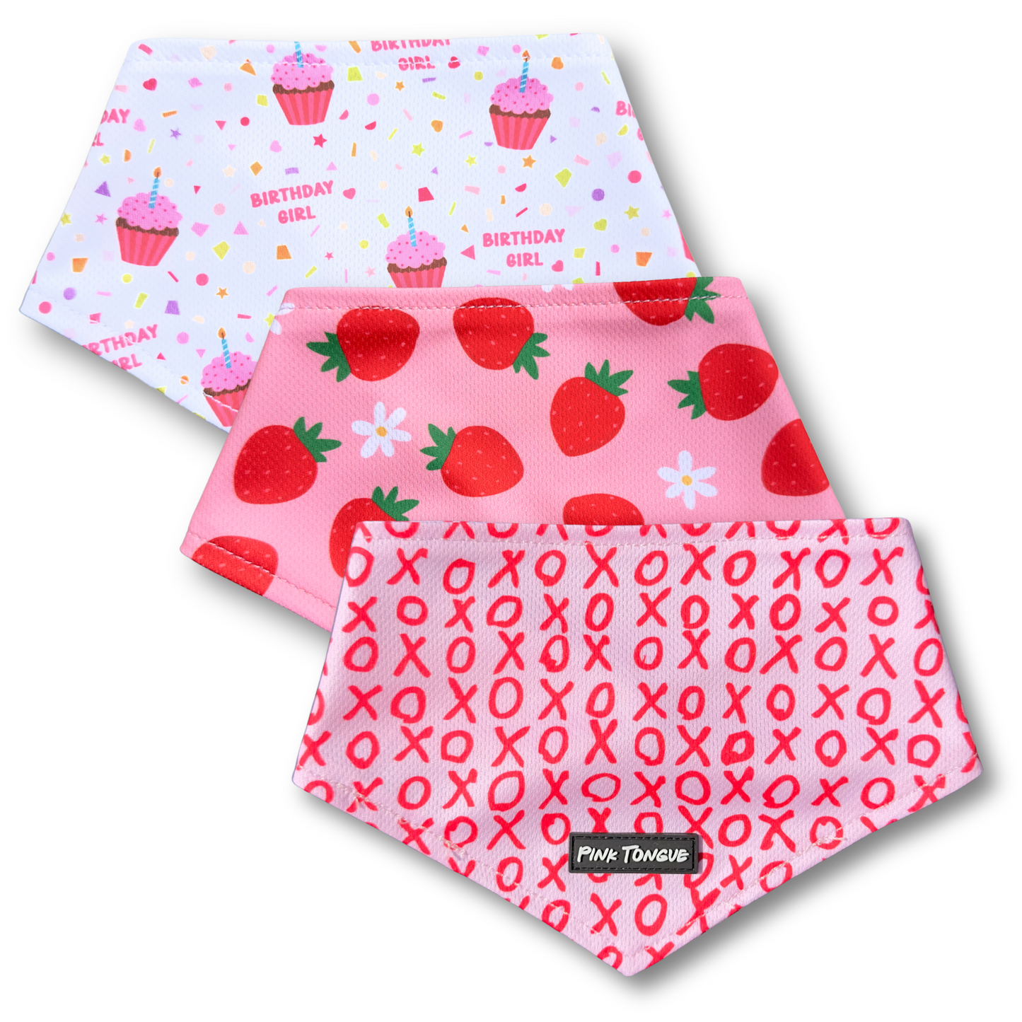 Three pink patterned dog bandanas with 'Birthday Girl' design, strawberry pattern, and 'XOXO' pattern on a white background.