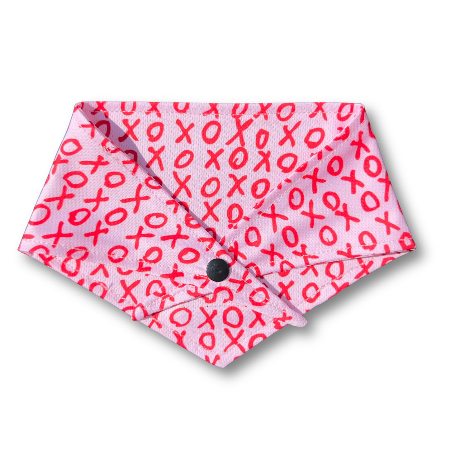 A charming Valentine's Day dog bandana featuring an XO pattern, perfect for celebrating love with your pup. Adjustable with tie and button options for a secure and stylish fit.